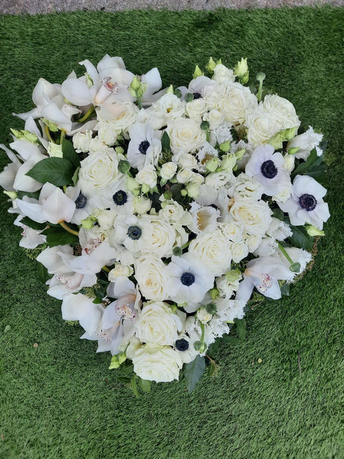 Un coeur de fleur blanches composé de pois de senteurs et roses réalisé avec soin par Rouge Pivoine Fleuriste à Caen