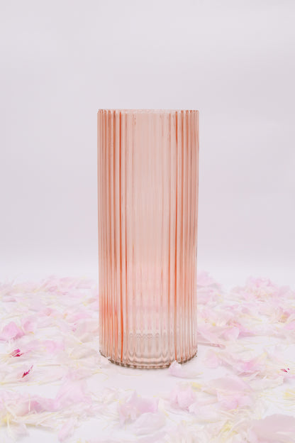 Vase cylindrique rose seul, en verre transparent à fines côtes verticales.